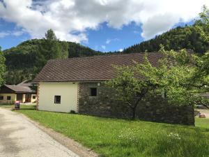 ein Haus mit einer Steinmauer neben einer Straße in der Unterkunft Beerenthal in Karnberg