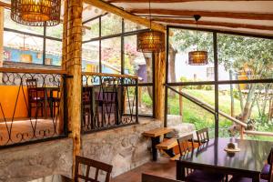 a restaurant with a table and chairs and windows at Casa de La Chola in Ollantaytambo