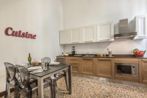 a kitchen with a table and chairs in a kitchen at Ca' del Monastero 4 Collection Apartment up to 8 Guests with Lift in Venice
