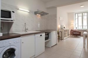 een keuken met een wasmachine en een wastafel bij La Terrasse de Jules in Carcassonne