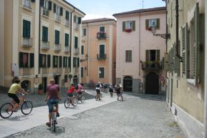 un grupo de personas montando bicicletas por una calle en Hotel La Meridiana, en Acqui Terme