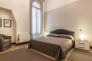 een slaapkamer met een bed, een stoel en een raam bij Ca' del Monastero 4 Collection Apartment up to 8 Guests with Lift in Venetië