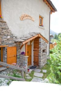 a house with a sign on the side of it at Chalet la Lauzette in Bessans +20 photos