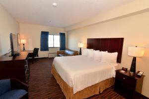 a hotel room with a bed and a desk at Cobblestone Inn & Suites - Holstein in Holstein