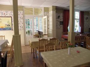 - une salle à manger avec des tables, des chaises et des fenêtres dans l'établissement Villa Katariina, à Pärnu