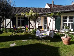 een tafel en stoelen in de tuin van een huis bij Les oyats in Le Crotoy