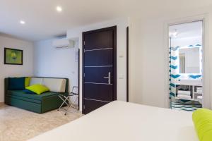 a bedroom with a bed and a couch and a window at Sorrento Flats in Sorrento