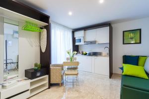 a living room with a green couch and a kitchen at Sorrento Flats in Sorrento