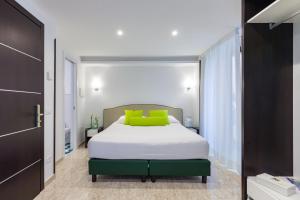 a bedroom with a white bed with green pillows at Sorrento Flats in Sorrento