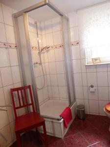 a shower with a red chair in a bathroom at Basislager Hohnstein - Familie Lösel in Ehrenberg