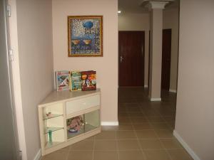 a hallway with a book shelf and a picture on the wall at Home Away From Home in Skopje