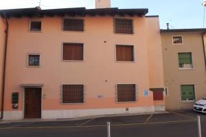 an orange building with barred windows and a parking lot at Richi Rent 01 in Verona