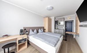a small bedroom with a bed and a desk at centerroom München City in Munich