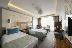 um quarto de hotel com duas camas e uma televisão em Style Star Hotel Cihangir em Istambul