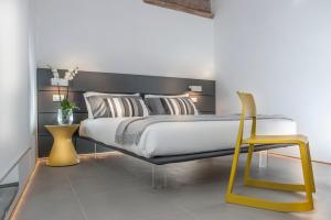 a bedroom with a large bed and a yellow chair at B&B First Floor in Rome