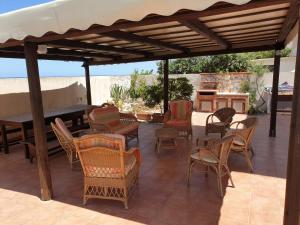un patio con sillas, una mesa y un piano en Da Giacomina en Marausa