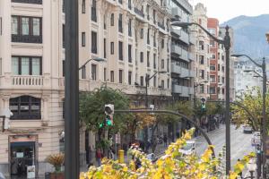 une rue urbaine avec un feu vert et des bâtiments dans l'établissement LUXURY GUGGENHEIM MUSEUM, à Bilbao