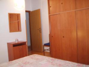 1 dormitorio con cama y armario de madera en Apartment Orbanić Cres, en Cres