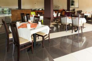 a dining room with a white table and chairs at Nican Resort Hotel Seguku Entebbe in Entebbe