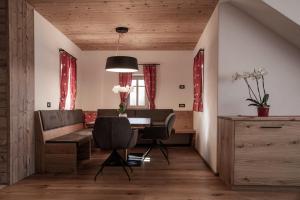 uma sala de jantar com uma mesa e cadeiras e um sofá em Penthouse Chalet Pichlerhof em Brunico