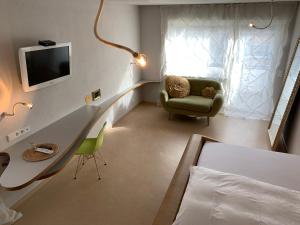 1 dormitorio con escritorio, silla y TV en hotelmärchen Garni, en Ludwigsburg