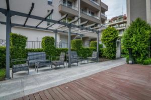 a group of benches sitting in a courtyard at Cozy One-bedroom Apartment in Night Breeze in Burgas