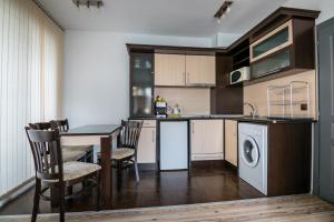 a kitchen with a table and a washing machine at Cozy One-bedroom Apartment in Night Breeze in Burgas