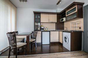 a kitchen with a table and a washing machine at Cozy One-bedroom Apartment in Night Breeze in Burgas