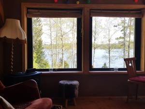 een kamer met 2 ramen met uitzicht op een meer bij Garpenbergs B&B, BnB in Garpenberg