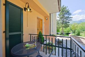 a table and chair on a balcony with a view at Residence Verde Quiete in Sarnano