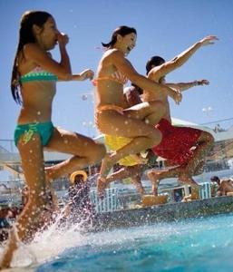 three girls jumping into the water at a beach at Apartment in Trakia Plaza in Sunny Beach