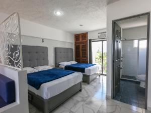 En eller flere senger på et rom på Hotel Pal Cozumel