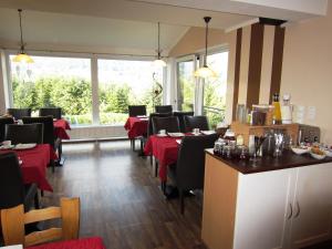 a restaurant with tables and chairs with red table cloth at Apartmenthaus Weber in Arrach