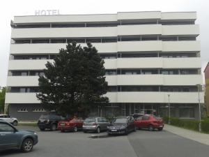 un estacionamiento con autos estacionados frente a un edificio en Hotel Slezan, en Bruntál
