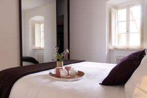 a white bed with a tray with flowers on it at Montalcino Loft in Montalcino