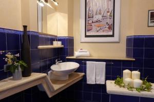 a blue tiled bathroom with a toilet and a sink at Montalcino Loft in Montalcino