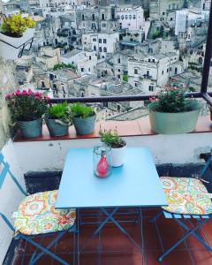 un tavolo e sedie su un balcone con vista sulla città di Sole di Paglia a Matera