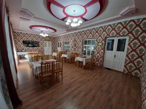 a dining room with tables and chairs and a ceiling at Saroy Guest house in Samarkand