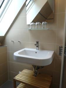 La salle de bains est pourvue d'un lavabo blanc et d'une fenêtre. dans l'établissement Alter Erker, à Fehmarn