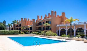 a large house with a swimming pool in front of it at Casa de Férias Vila Sol Golf in Quarteira