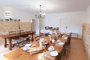 een eetkamer met een grote tafel en stoelen bij Le Relais Du Grand Logis in Mirabeau