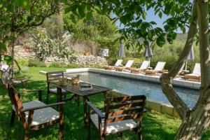 a table and chairs in front of a pool at Boutique Villa Kalliope in Gavalochori