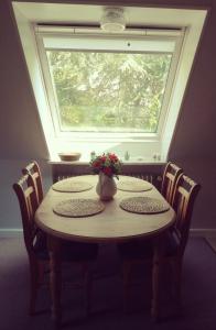 une table avec une fenêtre et un vase avec des fleurs dessus dans l'établissement Alter Erker, à Fehmarn