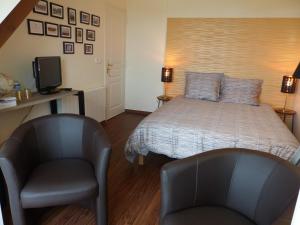 - une chambre avec un lit, 2 chaises et une télévision dans l'établissement LE RUBAN BLEU FACE A LA MER, à Arromanches-les-Bains