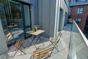 a patio with a table and chairs on a balcony at Hilltop Serviced Apartments- Northern Quarter in Manchester