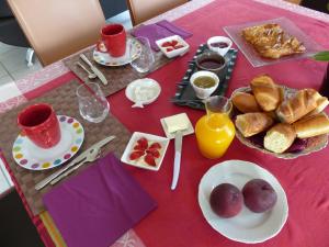 une table avec des assiettes de nourriture sur un tissu de table rose dans l'établissement LE RUBAN BLEU FACE A LA MER, à Arromanches-les-Bains