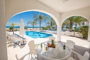 a patio with a table and chairs and a swimming pool at Sunrise Villas in Ayia Napa