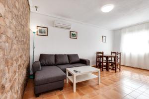a living room with a couch and a table at Apartamentos Atlas in Torrevieja