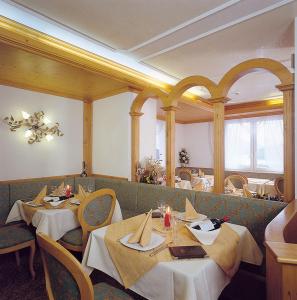 Hotel Olympia في مولفينو: غرفة طعام مع طاولتين وكراسي في مطعم