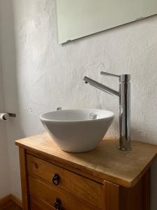 a white bowl sink sitting on top of a wooden cabinet at Deluxe Business City Apartments Metzingen Villa Landenberger in Metzingen